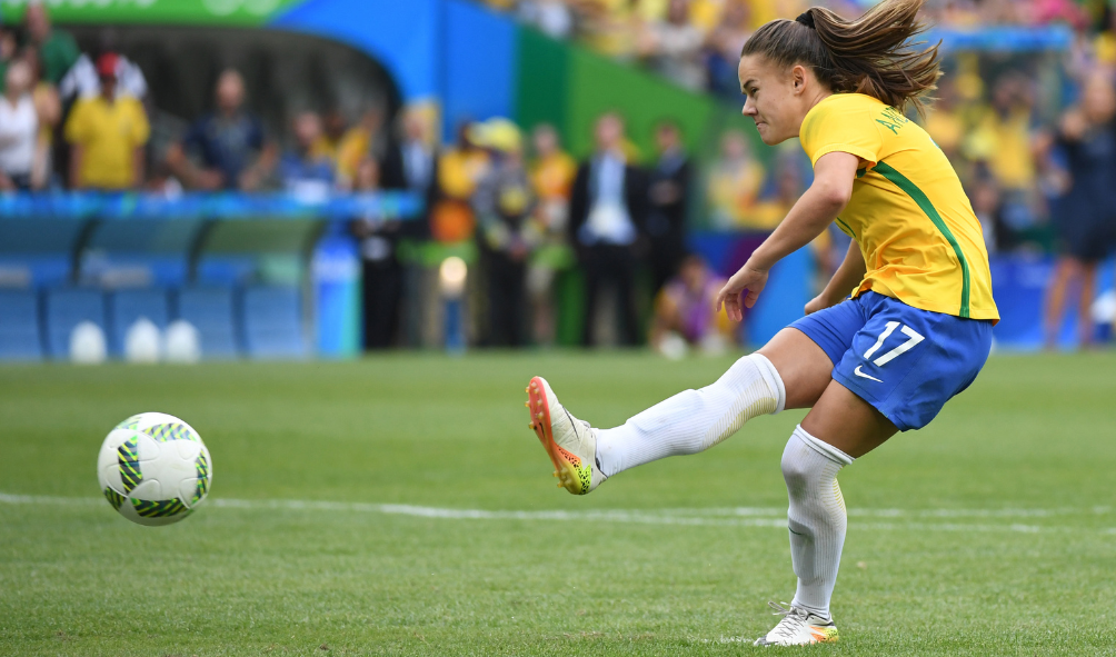 Jogadora da Seleção feminina de Futebol chutando a bola